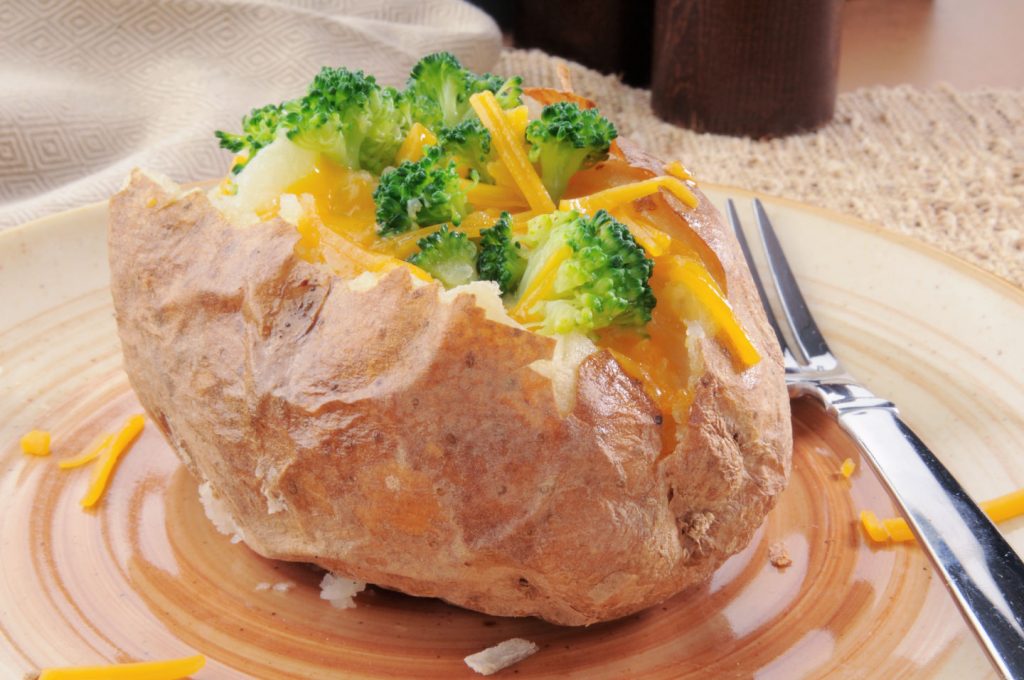 baked potato with broccoli and cheese on plate with fork dinner