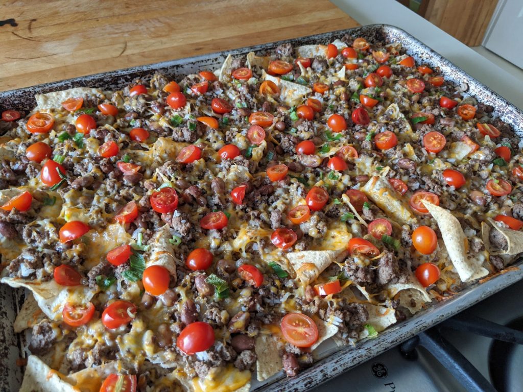 tortilla chips with topping on large baking sheet